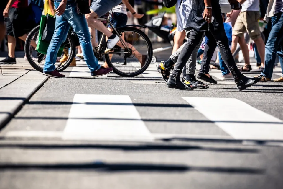 Low angle view of busy crosswalk with pedestrians and a bike.